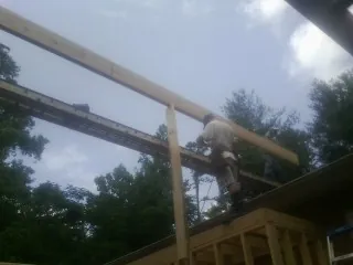 Carpenter setting a ridge beam over a new addition frame — Ice Dam Removal by Roofing Brothers in Brodhead