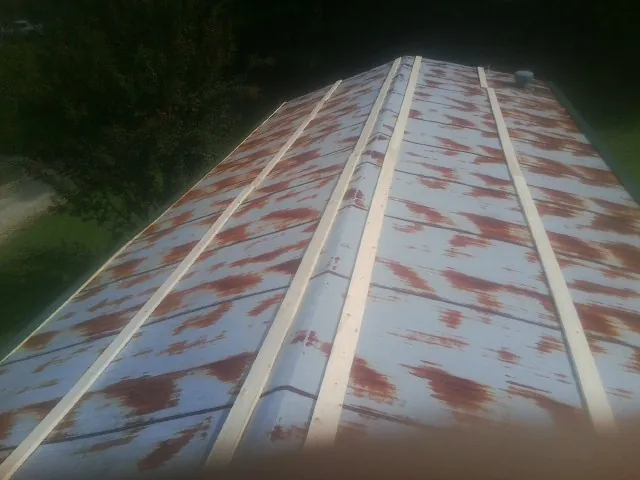 Rusted metal roof panels with new wood purlins before replacement — Storm Damage Roof Repair in Brodhead by Roofing Brothers