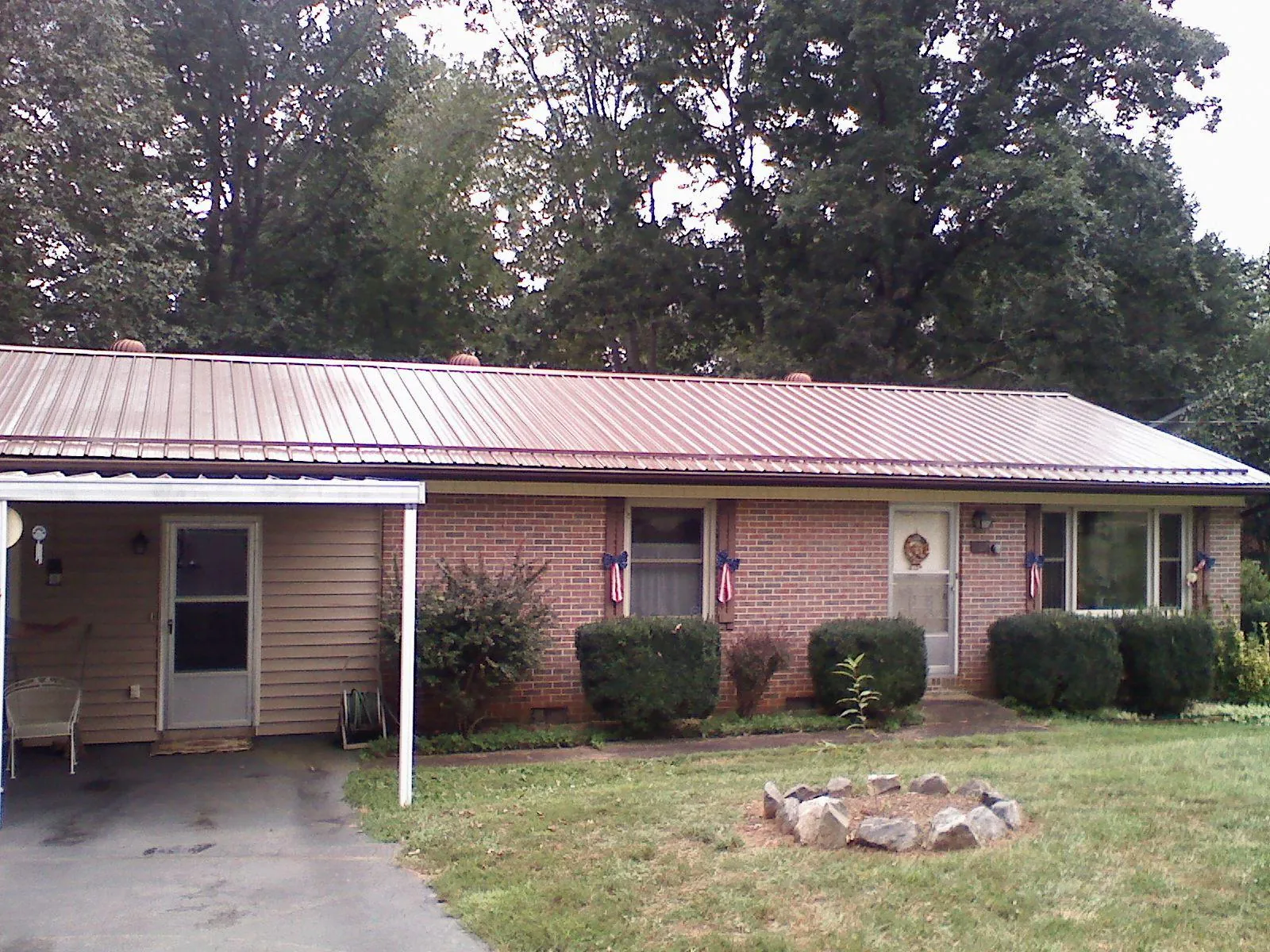 Bronze metal roof and carport on a brick ranch home — Roof Repair work by our crew in Brodhead